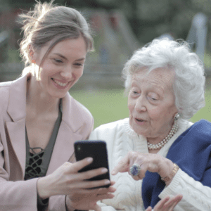 A woman showing her phone to an elderly person
